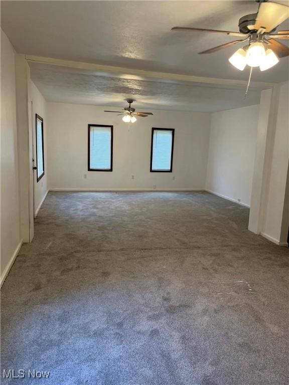 unfurnished room featuring ceiling fan and dark carpet