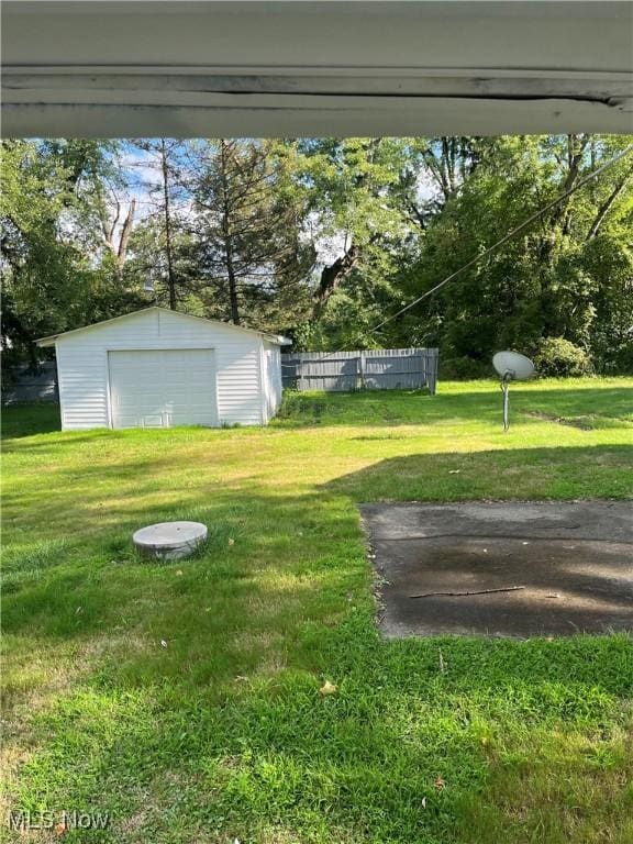 view of yard featuring a garage and an outbuilding