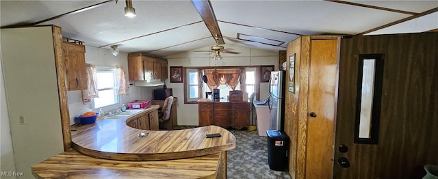 kitchen with ceiling fan, kitchen peninsula, stainless steel fridge, and lofted ceiling