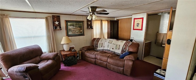 living room featuring ceiling fan, carpet, crown molding, and a textured ceiling