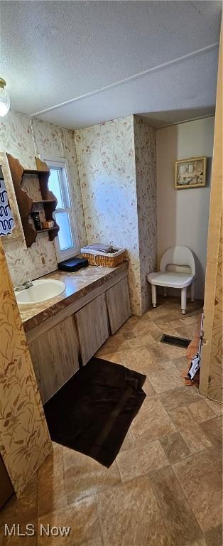 bathroom featuring toilet, sink, and a textured ceiling