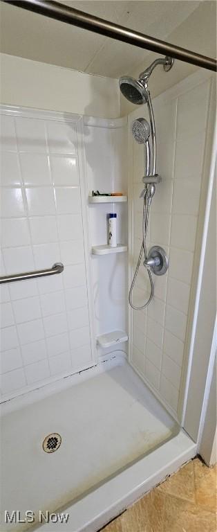 bathroom with tile patterned flooring and tiled shower