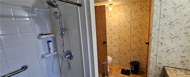 bathroom with toilet and a tile shower