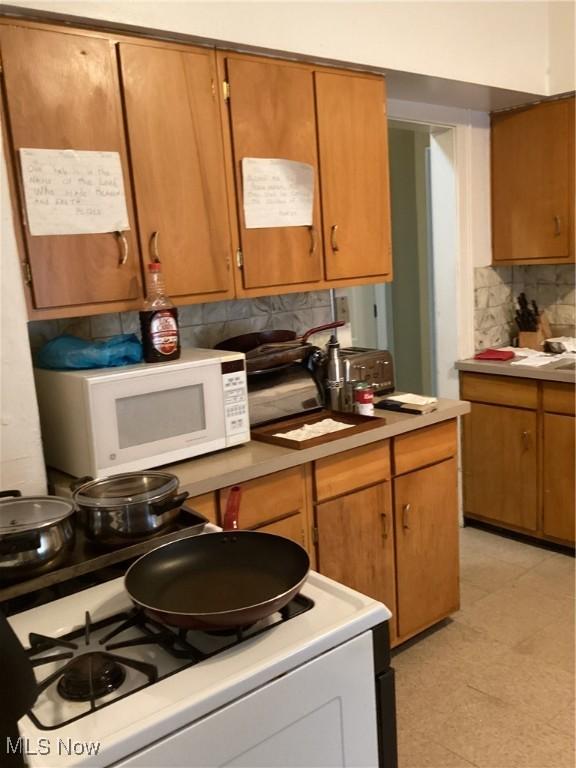 kitchen with white appliances and tasteful backsplash