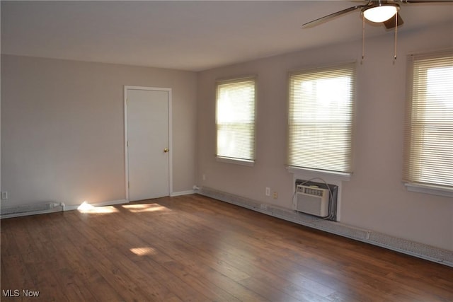 unfurnished room with ceiling fan, dark hardwood / wood-style flooring, and a wall mounted air conditioner