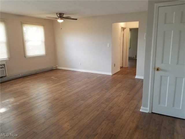 empty room featuring ceiling fan, a baseboard heating unit, and dark hardwood / wood-style flooring