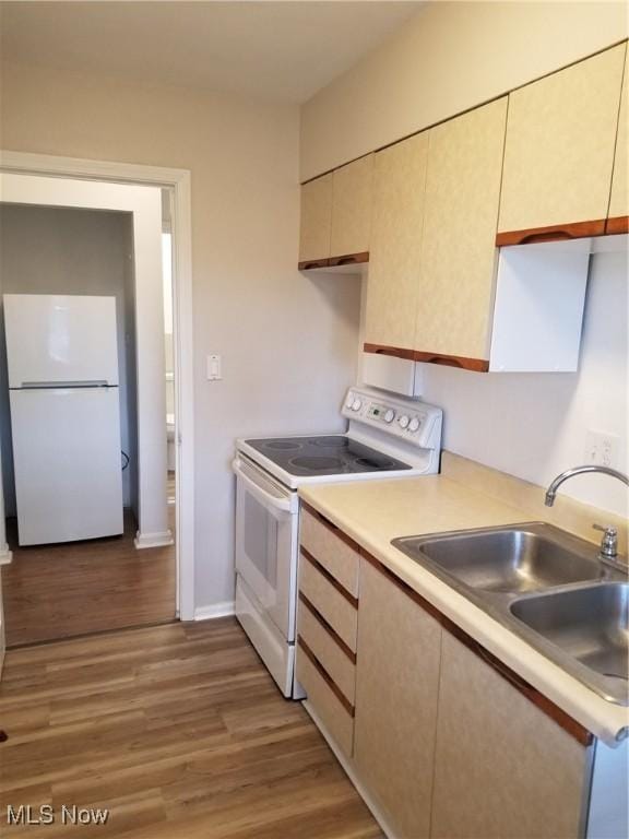 kitchen with light wood-type flooring, sink, and white appliances