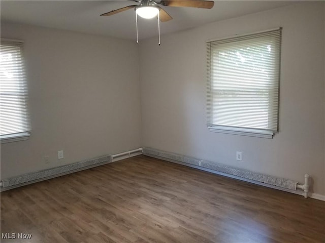 spare room with ceiling fan, a baseboard heating unit, and hardwood / wood-style flooring