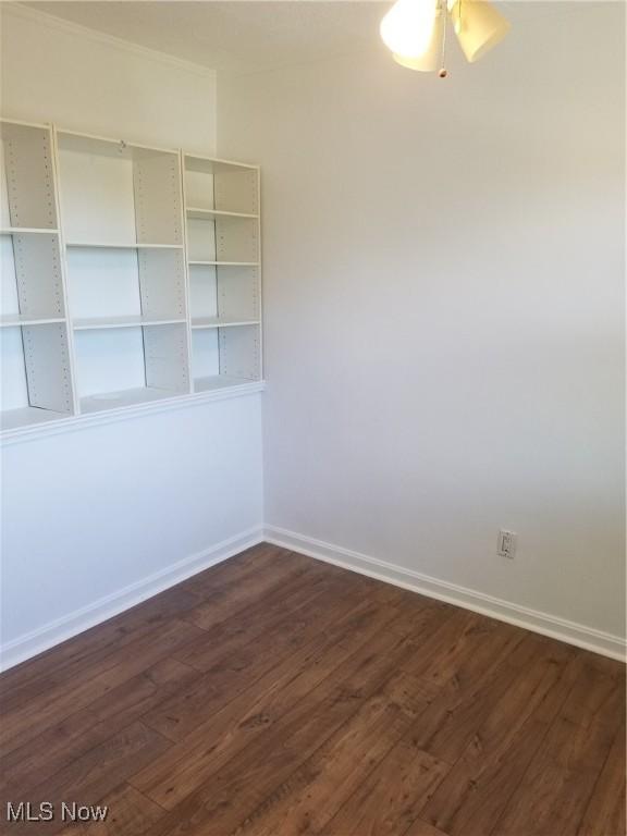 unfurnished room with dark wood-type flooring