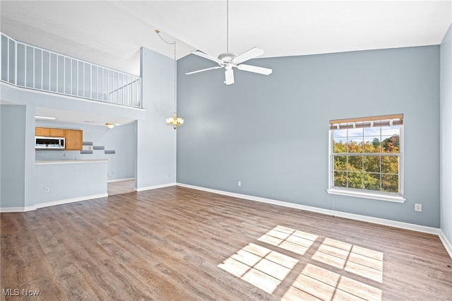 unfurnished living room with ceiling fan, high vaulted ceiling, and light hardwood / wood-style floors