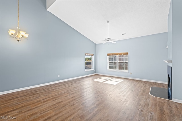 unfurnished living room with vaulted ceiling, ceiling fan with notable chandelier, and hardwood / wood-style flooring