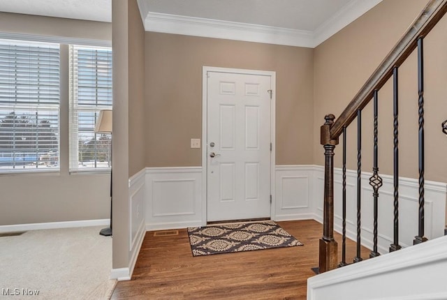 entrance foyer featuring plenty of natural light, ornamental molding, and hardwood / wood-style floors