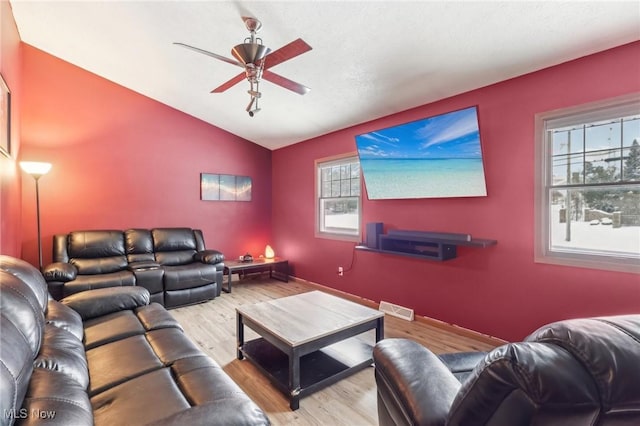 living room featuring lofted ceiling, light wood-type flooring, and ceiling fan