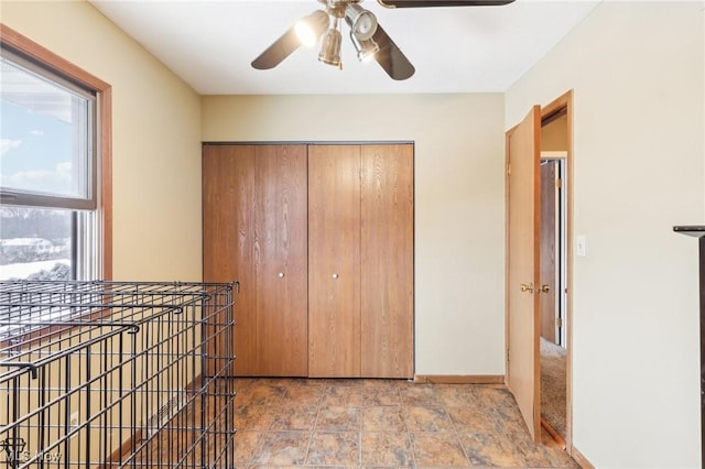 unfurnished bedroom with ceiling fan and a closet