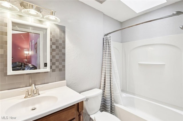 full bathroom with tasteful backsplash, vanity, toilet, shower / bath combo, and a skylight