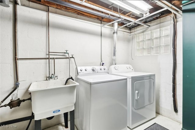 clothes washing area with washer and clothes dryer and sink