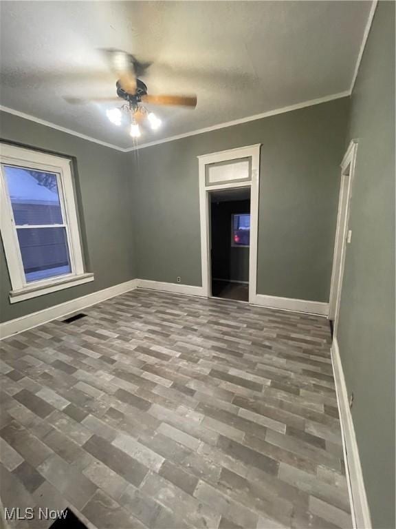 unfurnished room featuring ceiling fan and ornamental molding