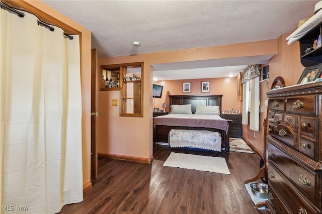 bedroom with dark wood-type flooring and a textured ceiling