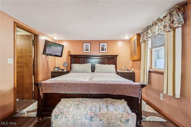 bedroom with dark hardwood / wood-style floors