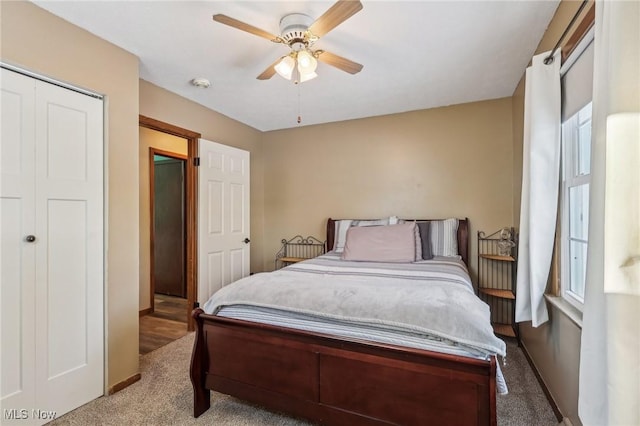 carpeted bedroom with ceiling fan and a closet