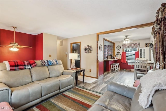 living room featuring light wood-type flooring and ceiling fan