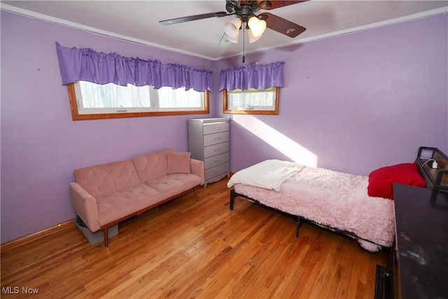 bedroom featuring ceiling fan, crown molding, and light hardwood / wood-style floors