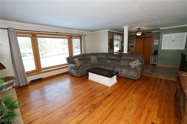 living room featuring ornamental molding, wood-type flooring, and decorative columns