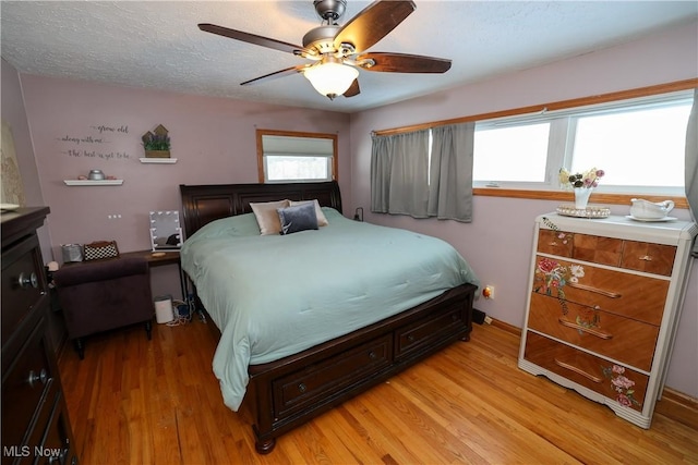 bedroom featuring ceiling fan, a textured ceiling, and light hardwood / wood-style flooring