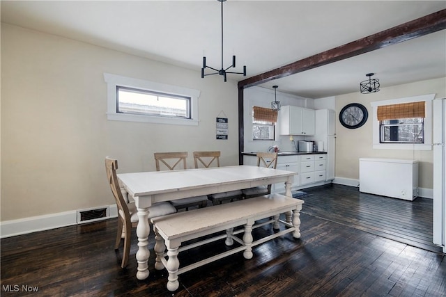 dining area featuring dark hardwood / wood-style flooring, beamed ceiling, and a notable chandelier