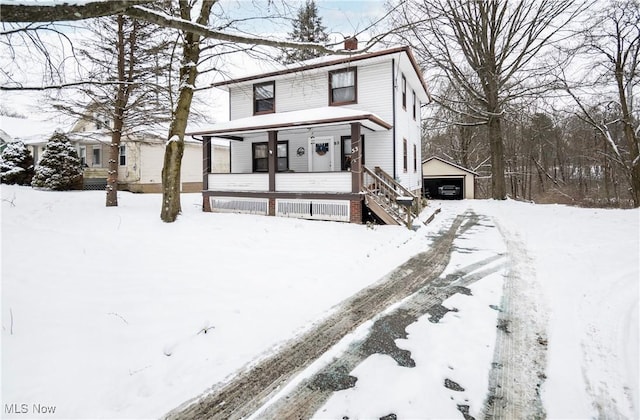 view of property with a garage, an outdoor structure, and a porch