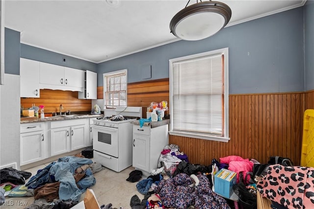 kitchen featuring white cabinets, white range with gas stovetop, sink, and ornamental molding