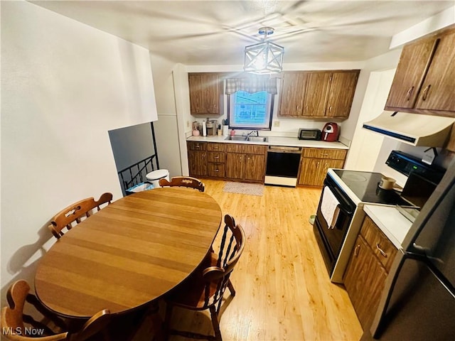 kitchen with decorative light fixtures, black dishwasher, light hardwood / wood-style floors, sink, and range with electric stovetop