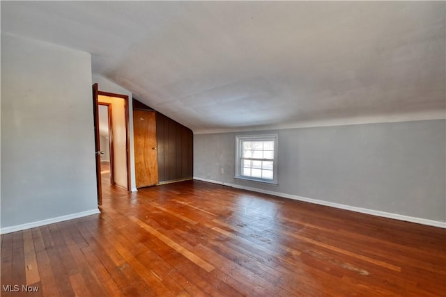 unfurnished room with vaulted ceiling and hardwood / wood-style flooring