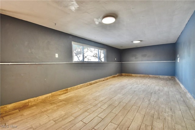 basement with light hardwood / wood-style floors