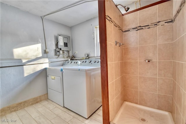 bathroom featuring separate washer and dryer, electric panel, and a tile shower