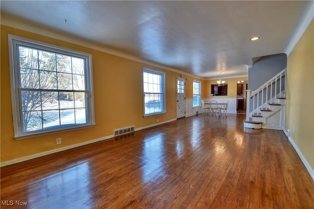 unfurnished living room featuring dark hardwood / wood-style flooring and an inviting chandelier