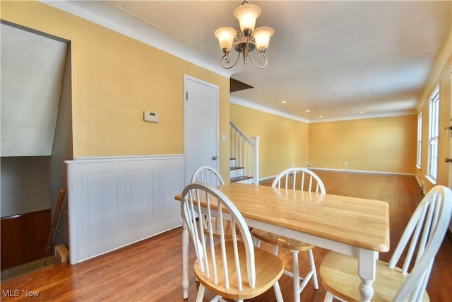 dining space with hardwood / wood-style floors and an inviting chandelier