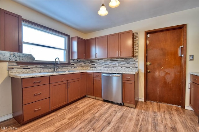 kitchen featuring decorative light fixtures, tasteful backsplash, light hardwood / wood-style floors, sink, and stainless steel dishwasher