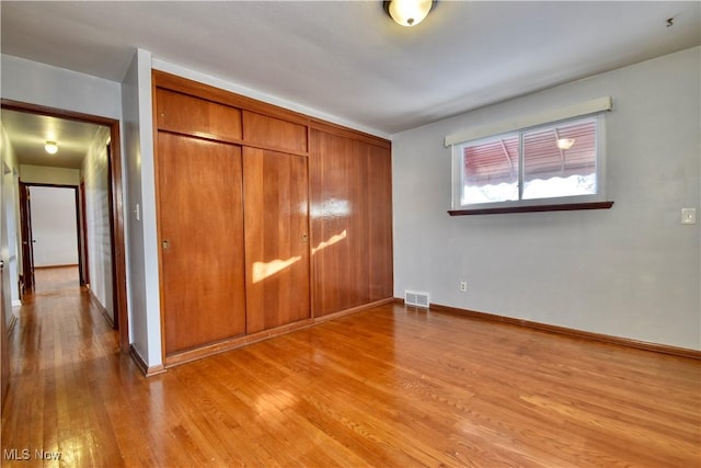 unfurnished bedroom with a closet and light hardwood / wood-style floors