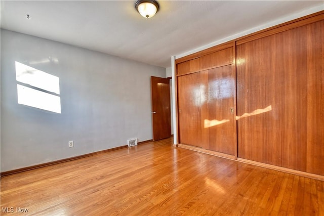 unfurnished bedroom with a closet and light hardwood / wood-style flooring