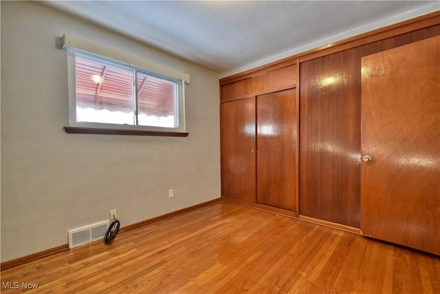 unfurnished bedroom featuring light hardwood / wood-style floors and a closet