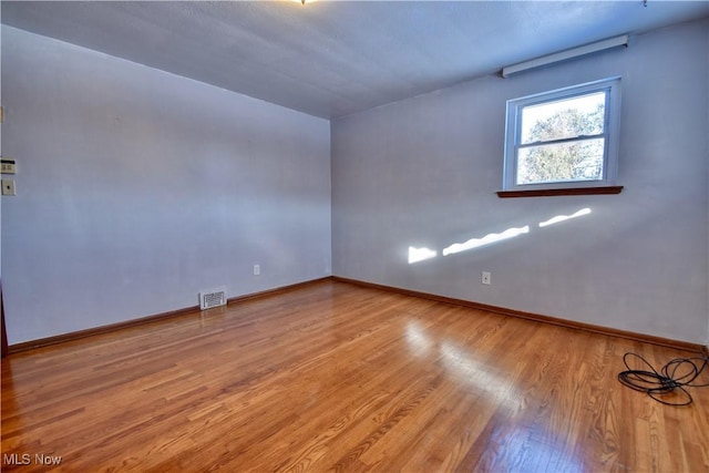 empty room with light hardwood / wood-style flooring