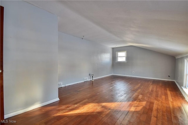 additional living space with lofted ceiling and dark hardwood / wood-style flooring