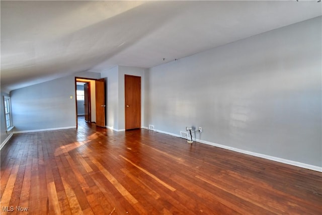 additional living space with dark hardwood / wood-style floors and lofted ceiling