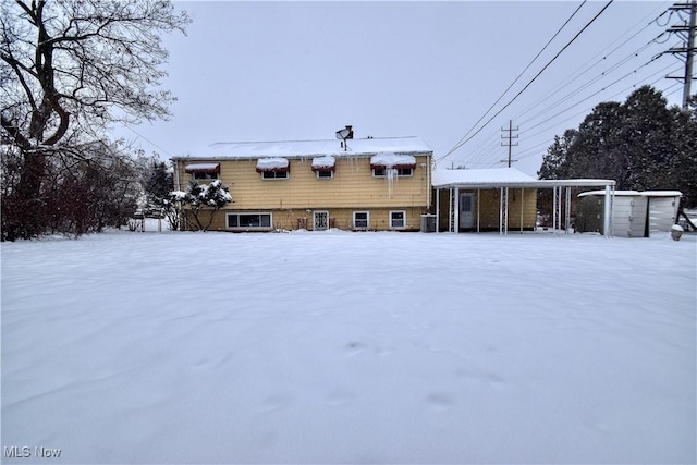 snow covered property with central AC unit