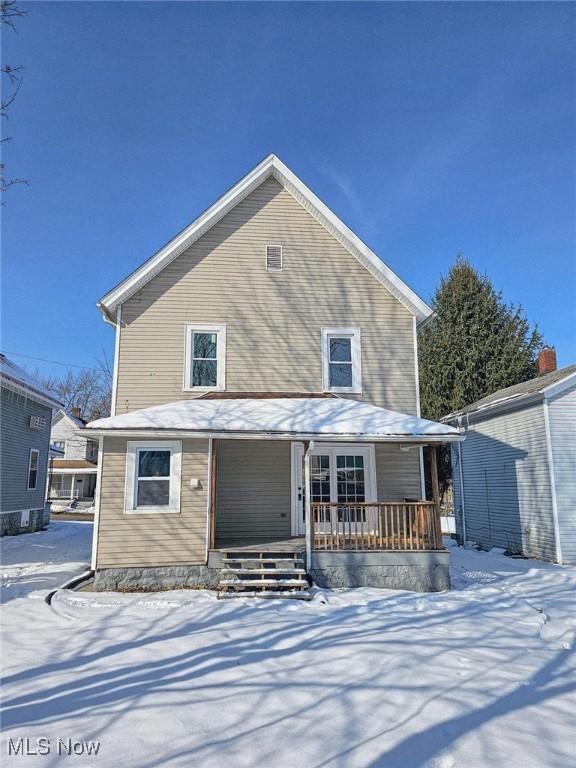 snow covered house with covered porch