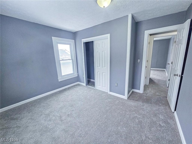 unfurnished bedroom with a closet, a textured ceiling, and carpet flooring