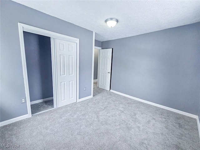 unfurnished bedroom with a closet, a textured ceiling, and carpet flooring