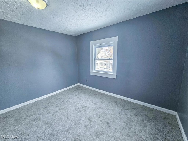 empty room with a textured ceiling and carpet flooring