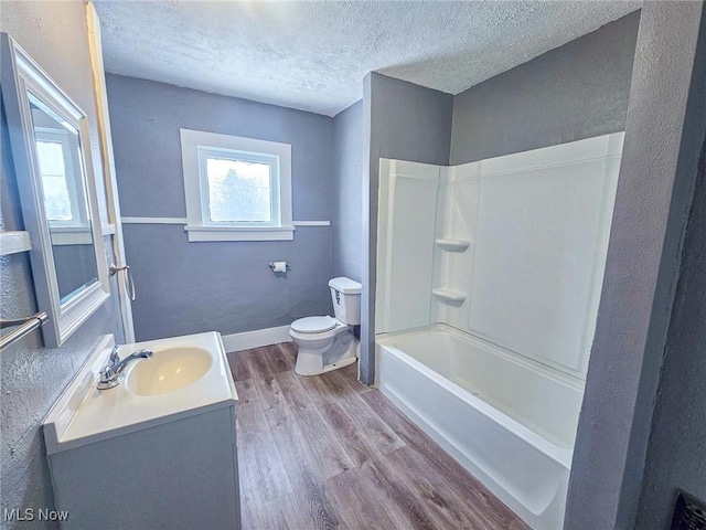 full bathroom featuring a textured ceiling, hardwood / wood-style floors, plenty of natural light, and vanity